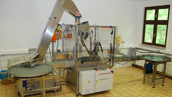Linear semi-automatic filling, capping and labelling machine from Küppersbusch.